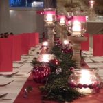 Die Tische im Gewölbekeller sind weihnachtlich mit roten Servietten und Kerzen geschmückt